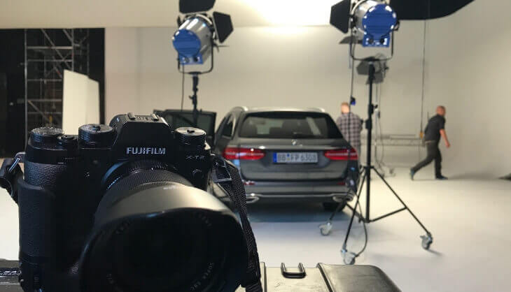 Une équipe travaillant sur un plateau de tournage filmant une voiture Mercedes